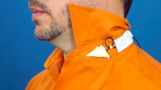 A still from “Hiding the Lavalier Mic (Part 1),” demonstrating the technique of taping a lavalier mic under a collar.