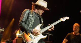 Kenny Wayne Shepherd gives off SRV vibes wearing a leather jacket, hat, and playing a battered Fender Stratocaster