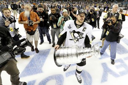 Sidney Crosby of the Pittsburgh Penguins carries the Stanley Cup