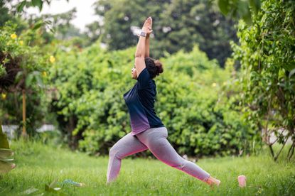 Woman performs yoga for knee pain flow in park