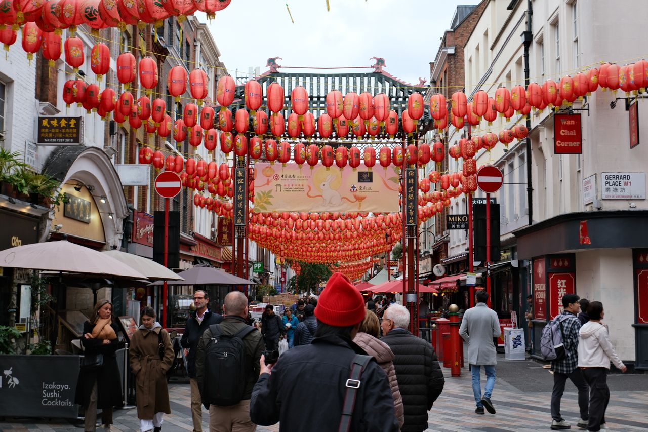 Ornate arch leading into Chinatown in London with paper lanterns across the street