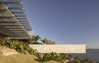 bridget house, a residence open towards sea views via glazed facade and metal structure framing the openings out to the sea