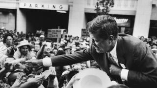 Massachusetts Sen. John F. Kennedy shakes hands with a crowd in Seattle following his speech on the first day of his presidential campaign. 