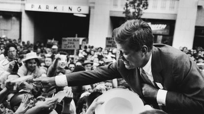 Massachusetts Sen. John F. Kennedy shakes hands with a crowd in Seattle following his speech on the first day of his presidential campaign. 