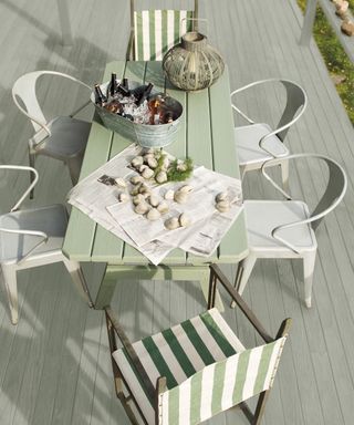 Decking and pastel green table with white and striped green chairs by Benjamin Moore