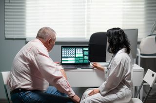 A doctor and patient going through a diagnosis 