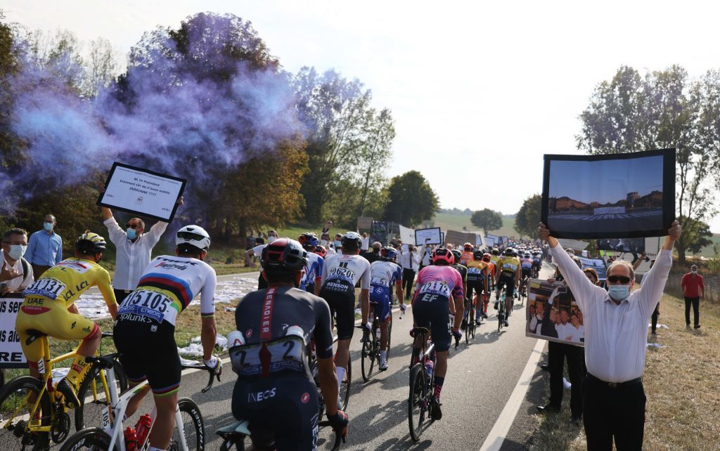 Team UAE Emirates rider Slovenias Tadej Pogacar L wearing the overall leaders yellow jersey rides with peloton as catering freelancers stage a protest during the 21st and last stage of the 107th edition of the Tour de France cycling race 122 km between ManteslaJolie and Champs Elysees Paris on September 20 2020 Photo by Kenzo Tribouillard AFP Photo by KENZO TRIBOUILLARDAFP via Getty Images