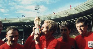 England captain Bobby Moore kissing the Jules Rimet trophy as the team celebrate winning the 1966 World Cup final against Germany at Wembley Stadium. His team mates are, left to right, George Cohen, Geoff Hurst and Martin Peters, 30th July 1966.