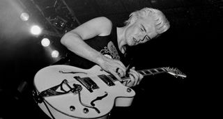 Billy Duffy of the Cult wears his blond hair in a pompadour and plays his Gretsch White Falcon onstage in this live shot from 1985.