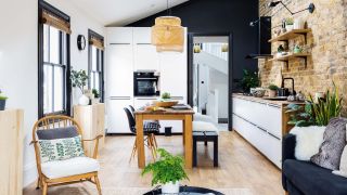a wooden open plan living room, kitchen and diner with kitchen cabinets and a dark blue wall