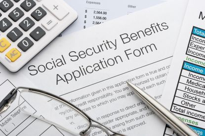 Close up of social security application with calculator and pen