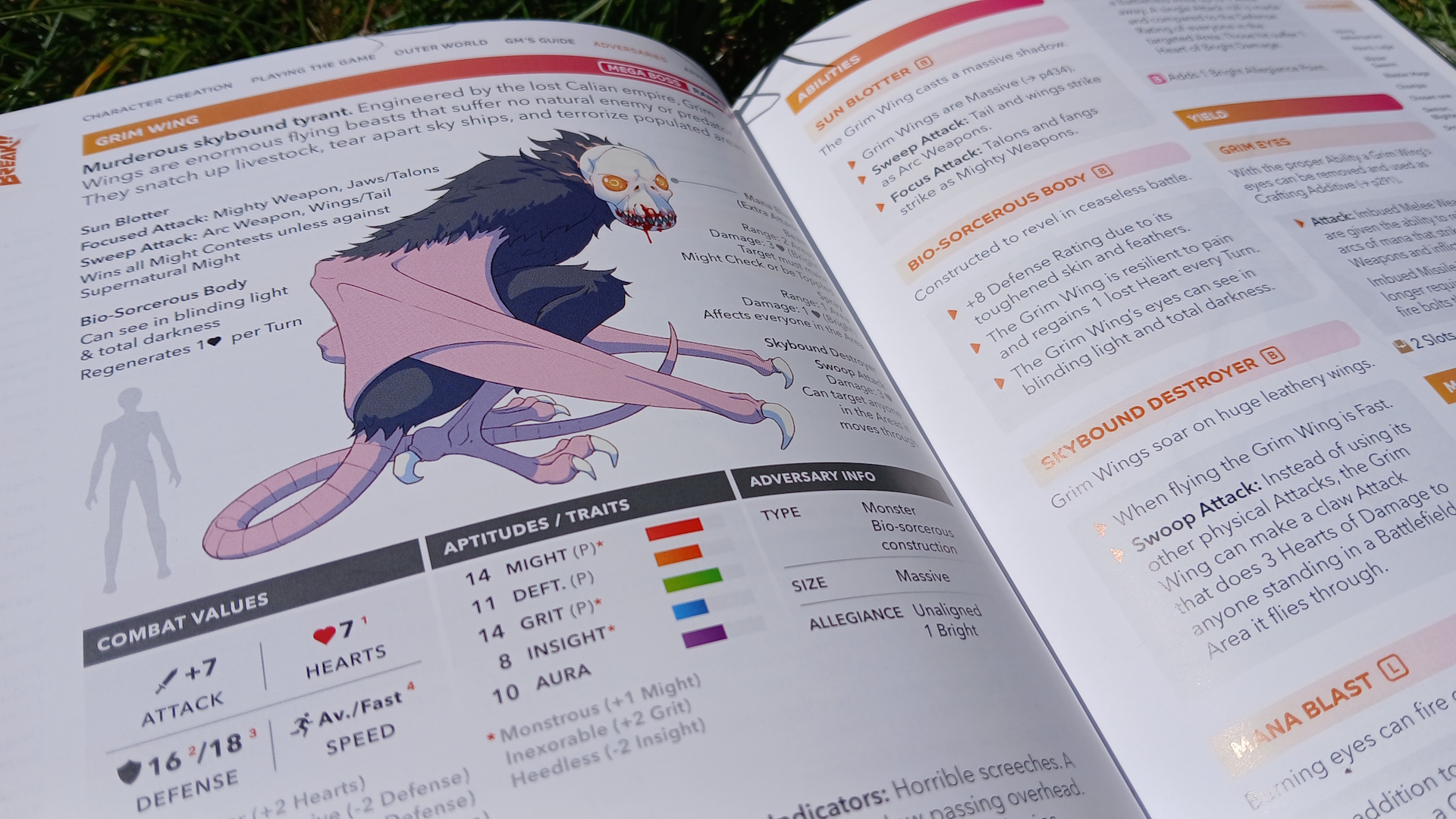 Open Break!! rulebook lying on a patch of grass, showing a skull-headed monster alongside stats