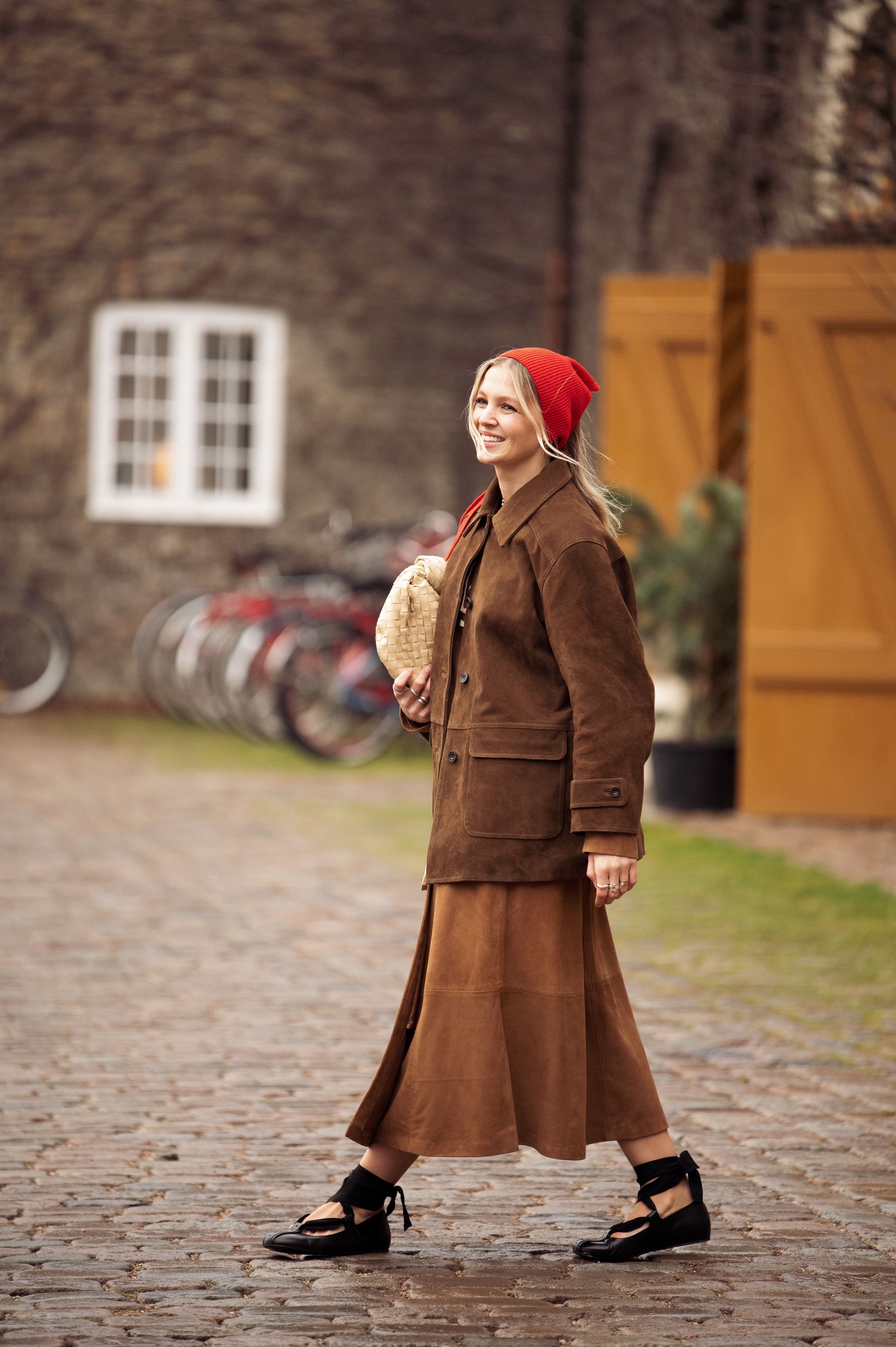 a woman wears a brown suede jacket