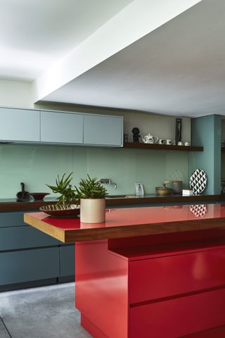 red kitchen island and blue cabinets in a galley kitchen