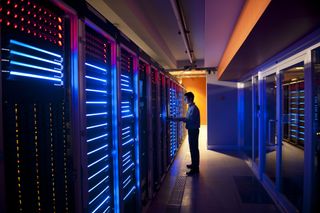 Cloud computing data center servers with man examining storage racks