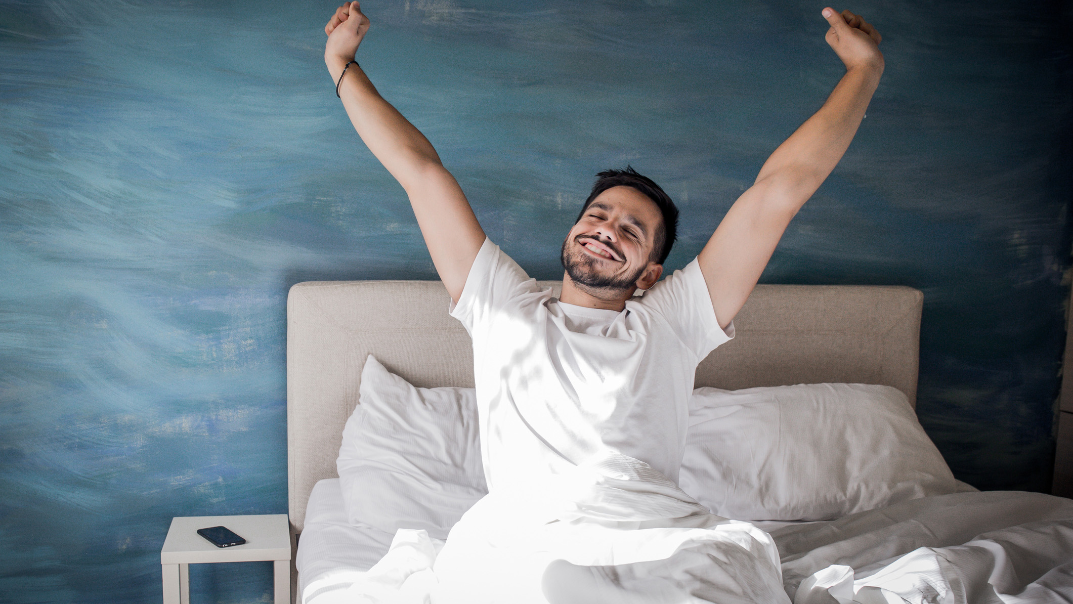 Un hombre se despierta feliz después de una gran noche de sueño.