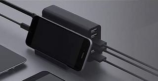 The Key Power Desktop Charging Station pictured on a grey surface charging a phone