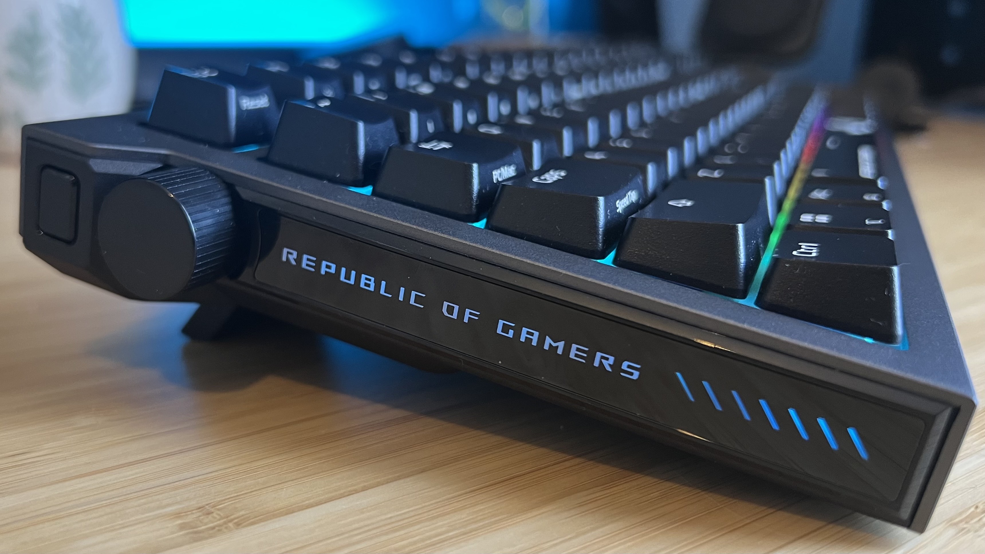 Close up on left side of Asus ROG Strix Morph 96 Wireless gaming keyboard showing RGB lighting, media control dial and extra button