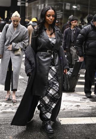 A guest wears a black duster jacket during New York Fashion Week's Fall/Winter 2025 shows