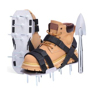 Tan work boots attached with black straps to a metal plate with spikes next to a cutting tool
