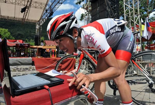 A member of the Japan National Team rider checks his bike transponder on the laptop