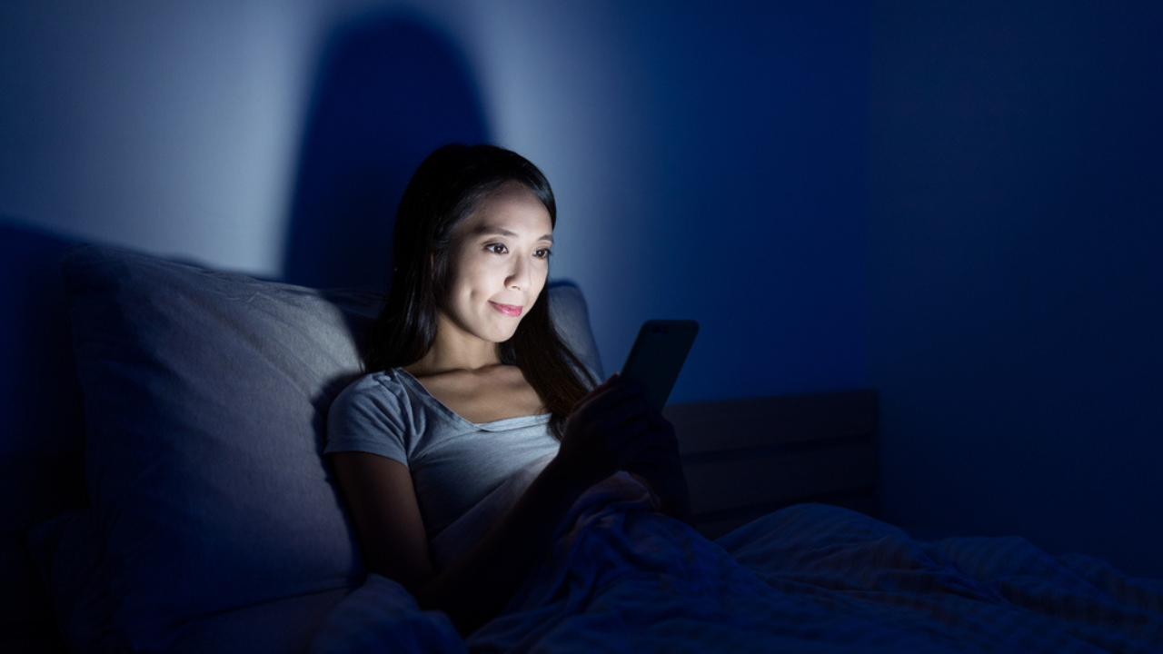 woman in bed on her phone