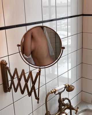 The reflection of a torso in a round mirror