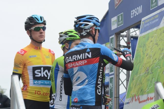 Bradley Wiggins waits to sign the route map behind Dan Martin