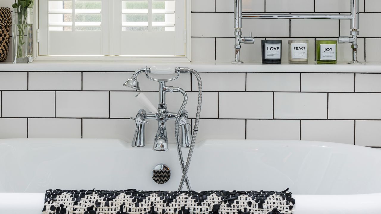 A bathroom with a bathtub and white tiles