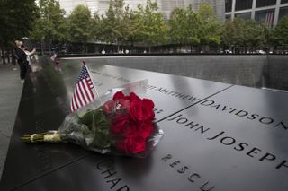 A U.S. flag and a flower are placed near a victim's name at the September 11 Memorial at Ground Zero on September 8, 2021 in New York, United States.