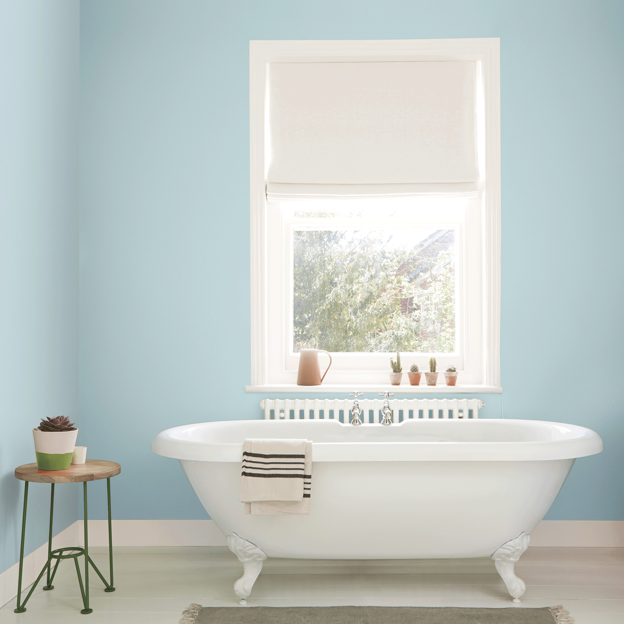 Blue bathroom with white bath and window