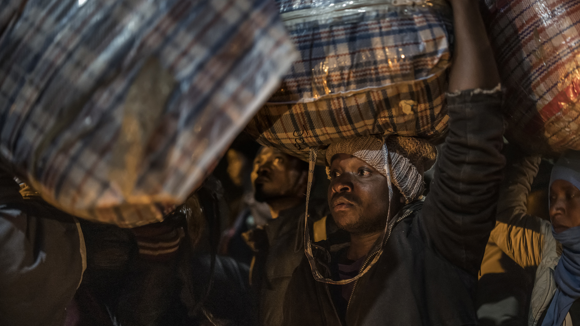 A Malawian migrant carries his belongings as he waits to board a bus in Johannesburg, South Africa, after violent clashes sparked a wave of repatriation among illegal migrants