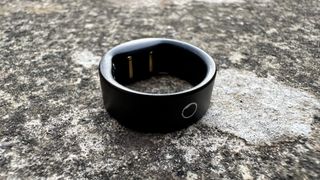 The Circular Ring Slim smart ring in black on a concrete surface.