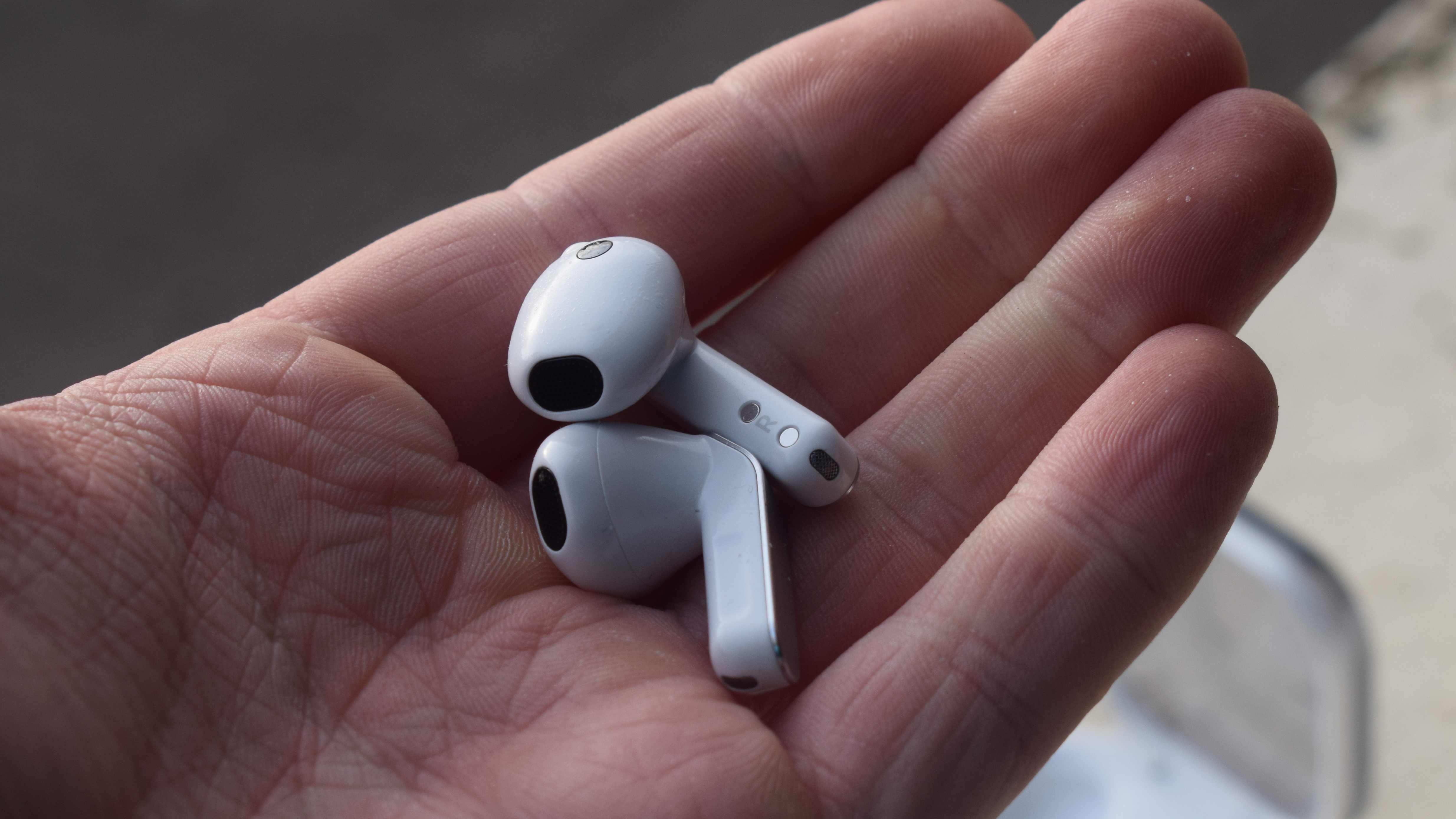 The Samsung Galaxy Buds 4 earbuds in a man's hand.