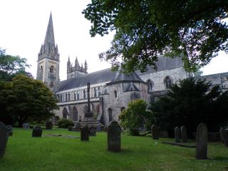 A church behind green grass and trees