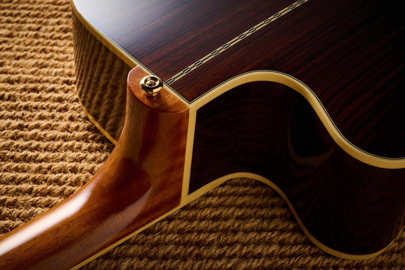 The Epiphone Inspired by Gibson Custom Hummingbird photographed in all its glory, in close-up and against a wheat-coloured rug.