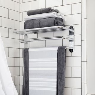 bathroom with white tiles on wall and towels rack