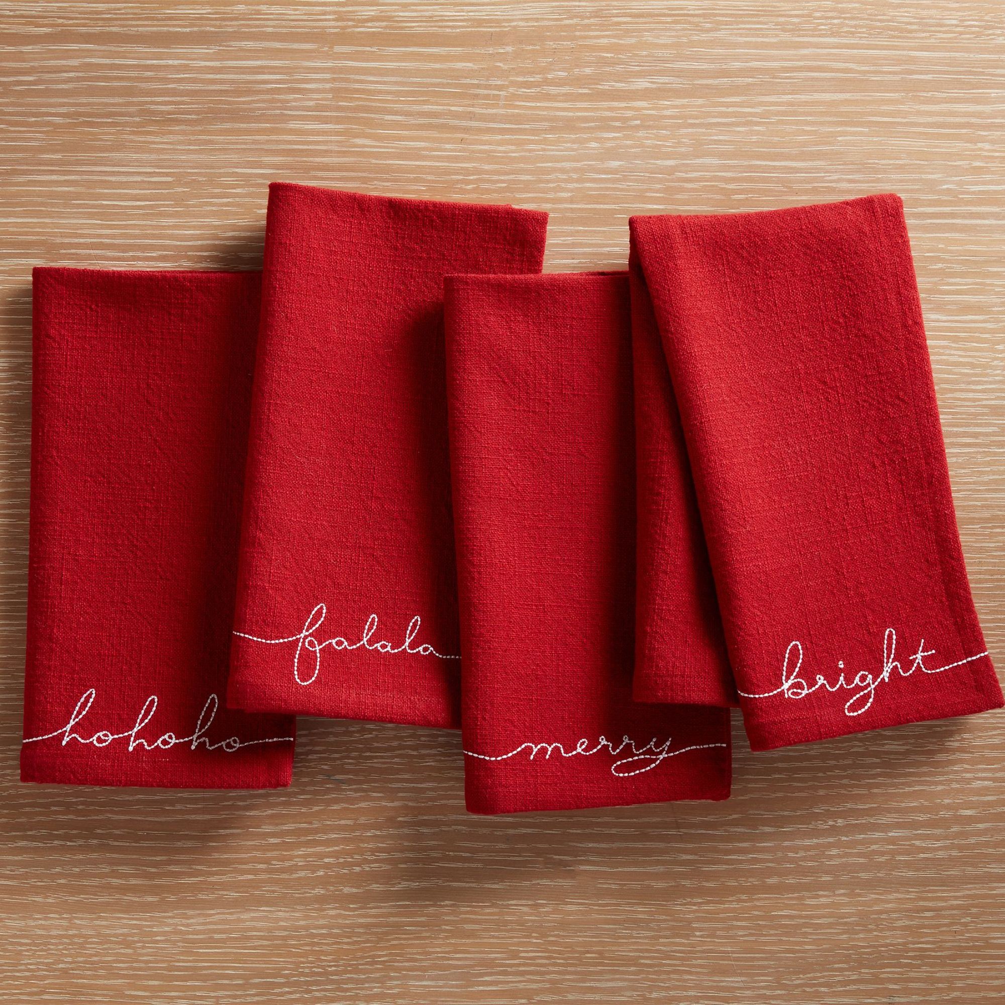 Red napkins with white embroidered Christmas messages