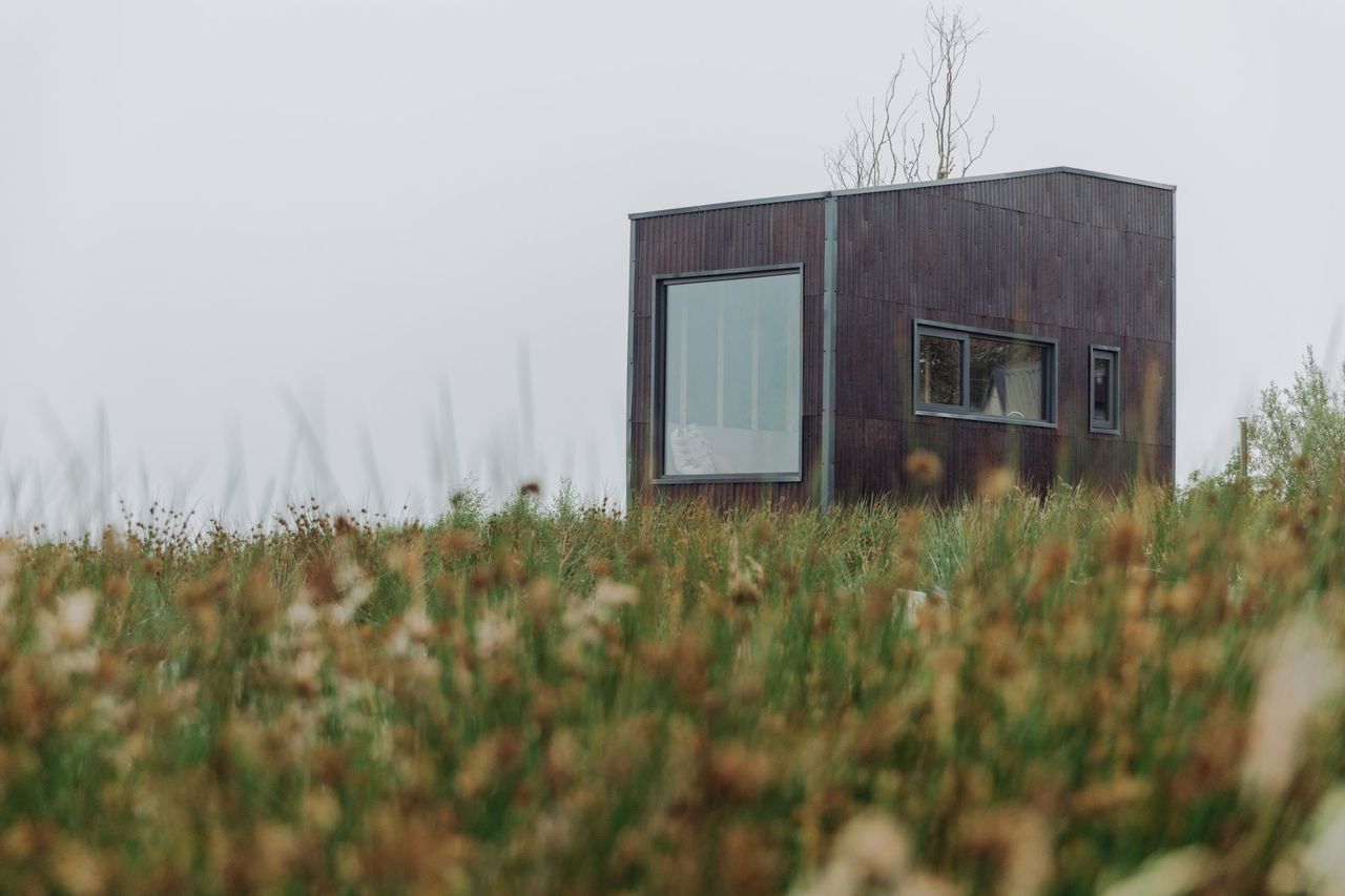 Exterior view of a tiny eco home on a hillside