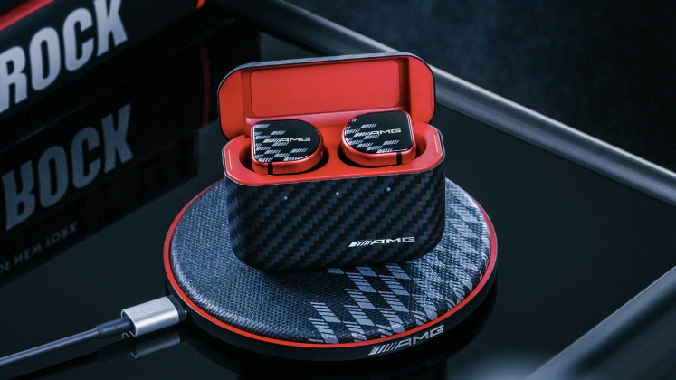 Master & Dynamic MW08 Sport Mercedes-AMG headphones on wireless charging cradle, on black background
