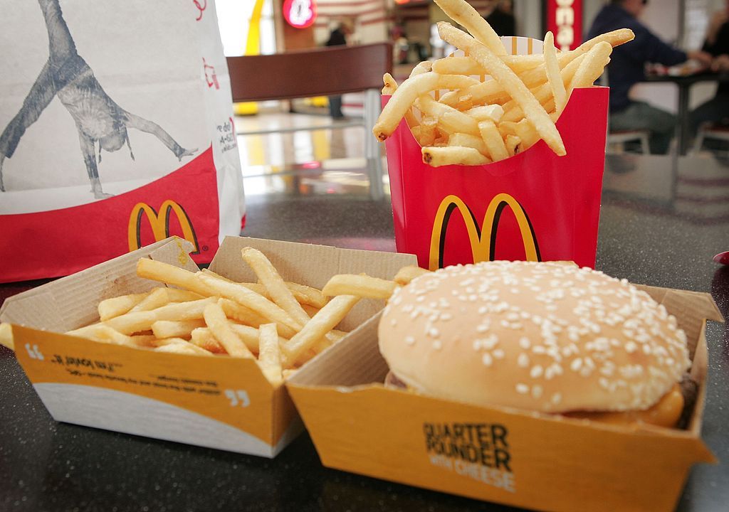 A quarter pounder with cheese sits in front of fries in a McDonald&amp;#039;s burger.