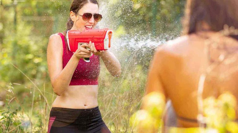 SPYRA water blaster being used by a woman in sunglasses