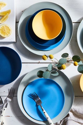 selection of blue, grey and yellow dinnerware on a table