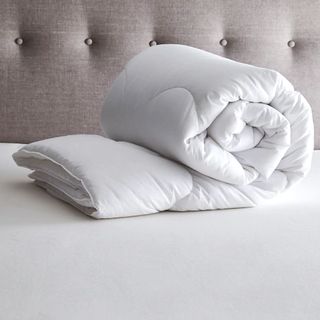 Fogarty duvet rolled up on a bed with an upholstered headboard