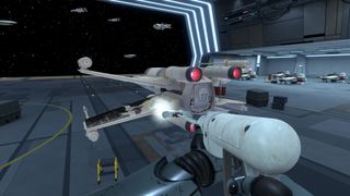 A screenshot from PowerWash Simulator 2: Star Wars DLC showing an X-wing inside a hangar being cleaned with a pressure washer.