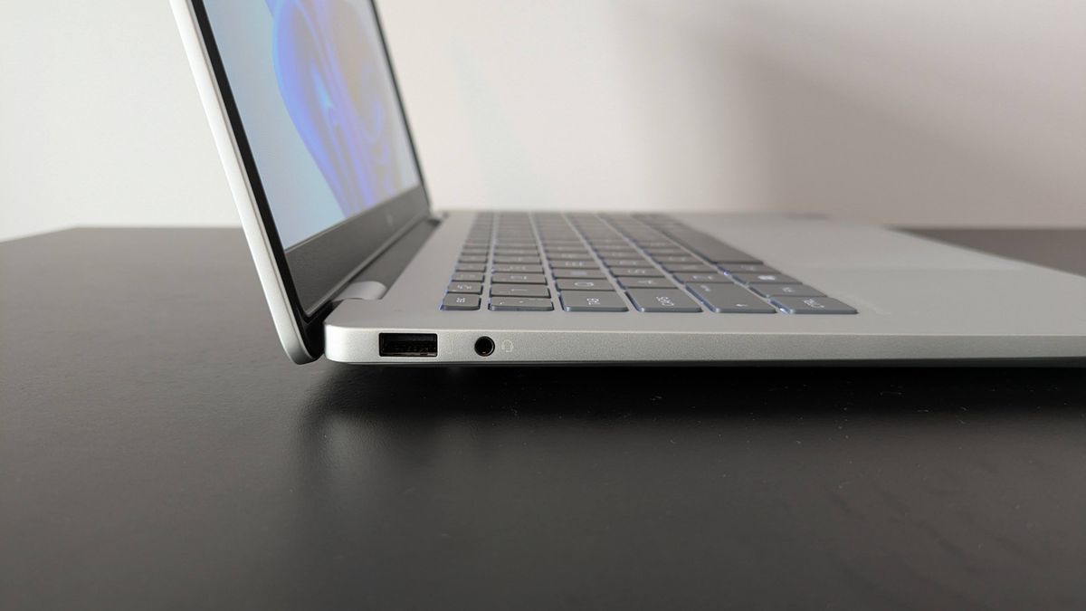Close-up of left-side ports on HP OmniBook 7 14-inch, on a black desk with white wall in background
