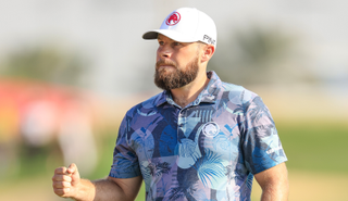 Tyrrell Hatton fist pumps as he walks off the green