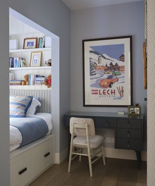 A boys bedroom with a separate bed nook and blue patterned wallpaper