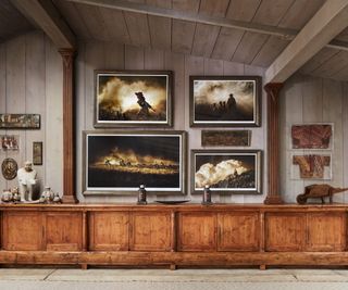 wooden sideboard with artwork above and concrete floor