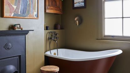 Olive green bathroom with dark red bath tub and black fireplace